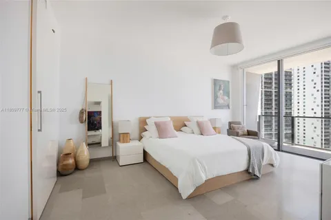 a bedroom with a bed and a large window