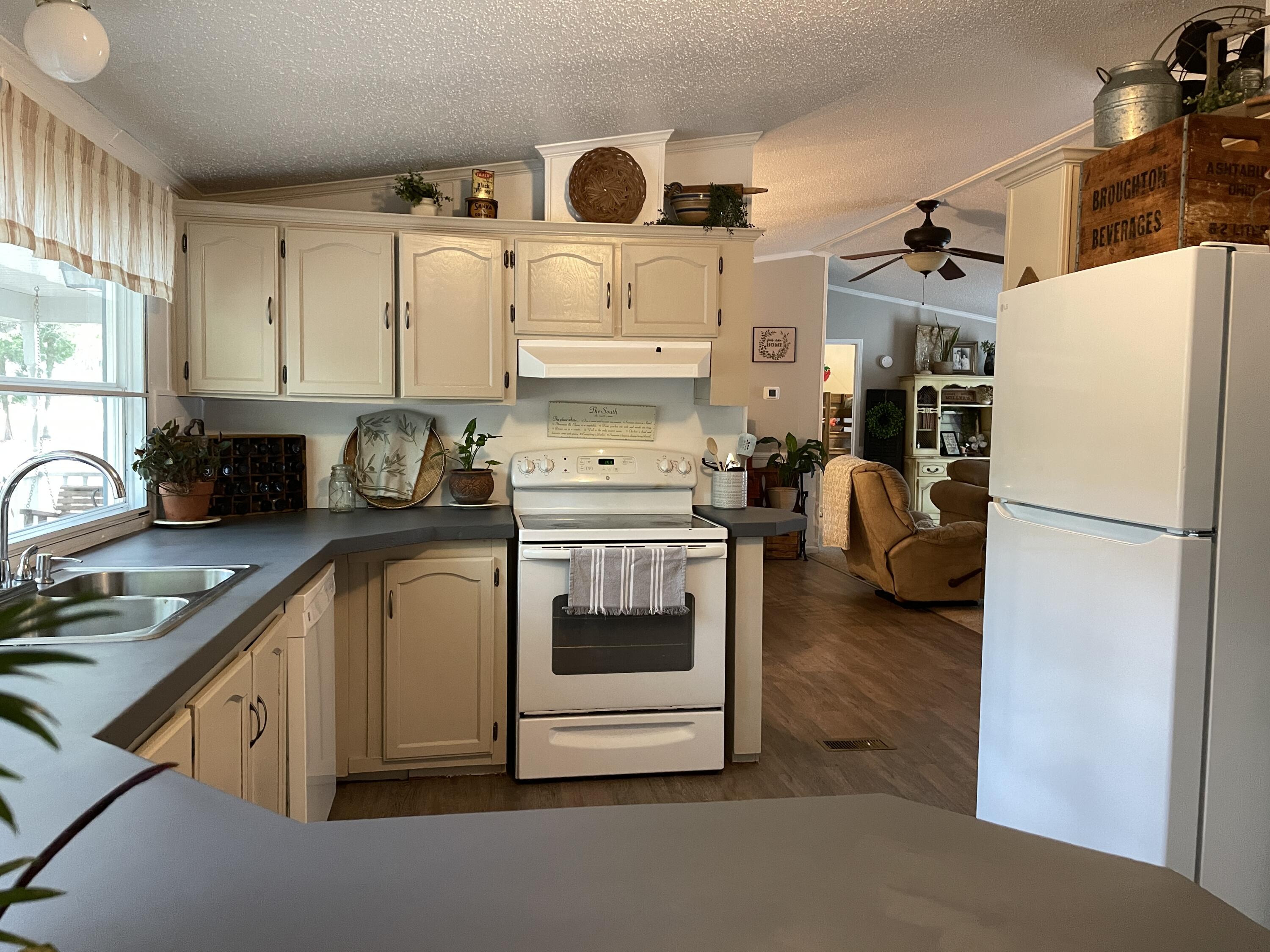 2166 Healing Springs Road Blackville, SC 29817 - Photo 10 of 43 a kitchen with stainless steel appliances granite countertop a refrigerator sink stove and white cabinets