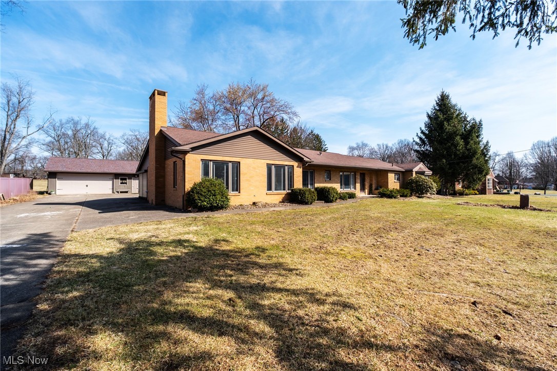 7059 Stewart Sharon Road Hubbard, OH 44425 - Photo 2 of 49 View of front of house with an attached garage, driveway, a chimney, and a front yard