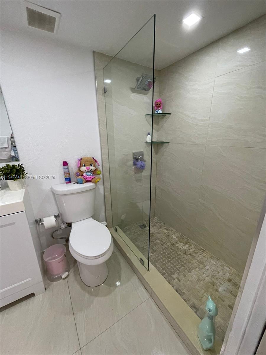 15221 Southwest 80th Street, Unit 313 Miami, FL 33193 - Photo 11 of 14 a bathroom with a toilet and a shower