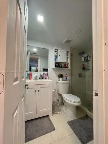 a bathroom with a sink toilet vanity and shower