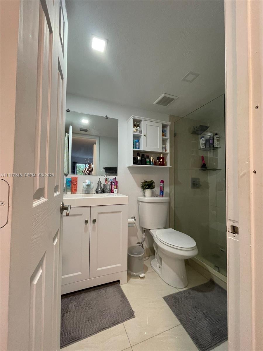 15221 Southwest 80th Street, Unit 313 Miami, FL 33193 - Photo 13 of 14 a bathroom with a sink toilet vanity and shower