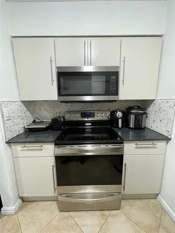 a stove top oven sitting inside of a kitchen