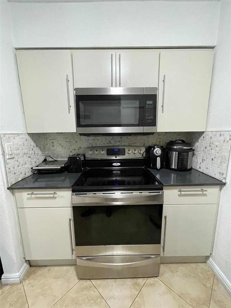 15221 Southwest 80th Street, Unit 313 Miami, FL 33193 - Photo 8 of 14 a stove top oven sitting inside of a kitchen