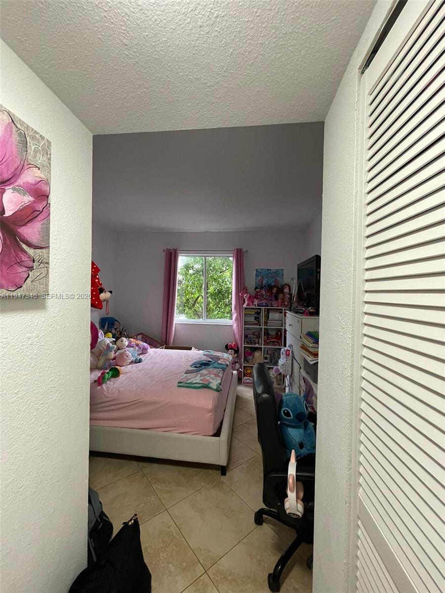 15221 Southwest 80th Street, Unit 313 Miami, FL 33193 - Photo 10 of 14 a bedroom with a bed and a window