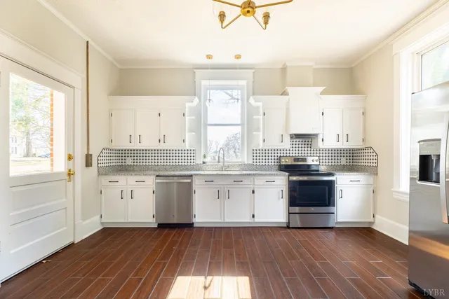 a kitchen with granite countertop white cabinets and white appliances