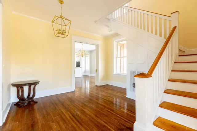 a view of a hallway with wooden floor and staircase