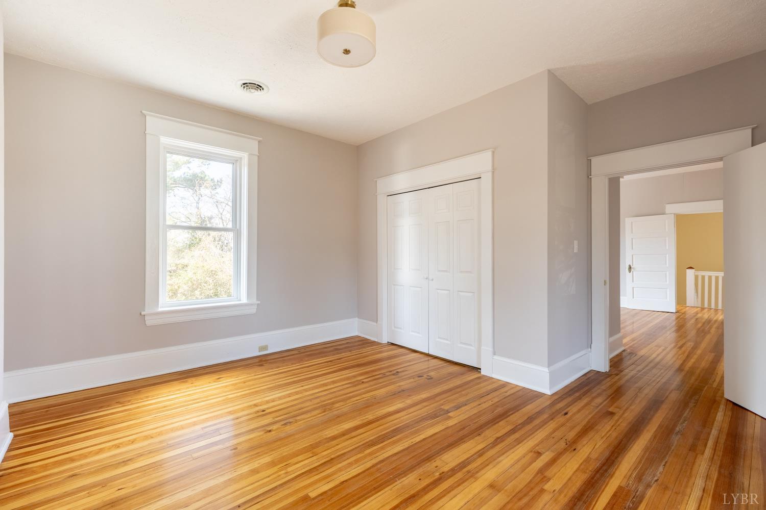 211 Cook Avenue Brookneal, VA 24528 - Photo 23 of 50 an empty room with wooden floor and windows