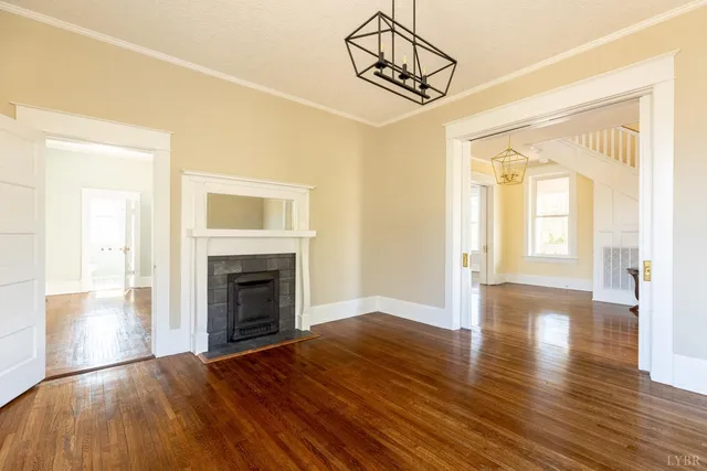 a view of empty room with wooden floor and fireplace