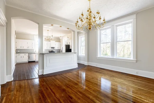 a large kitchen with stainless steel appliances sink refrigerator and white cabinets