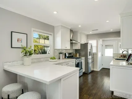 a kitchen with a refrigerator a sink dishwasher stove and oven with wooden floor