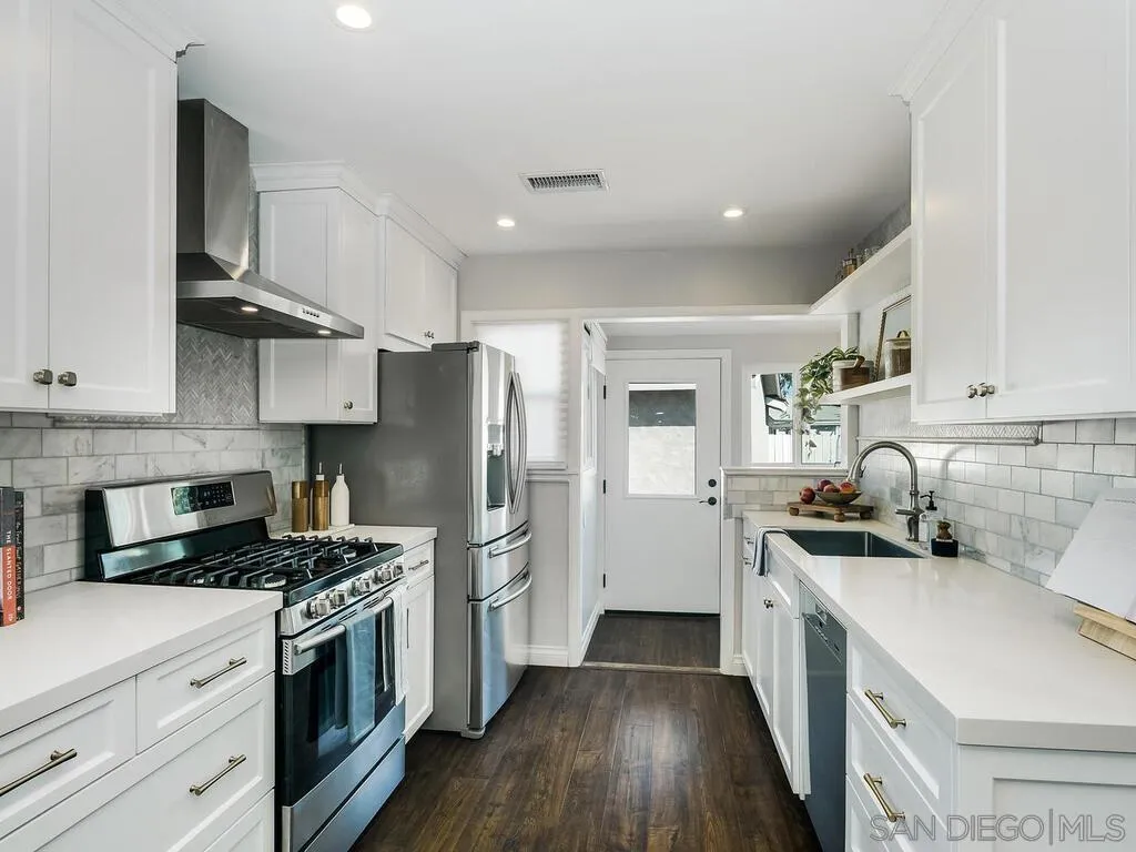 4751 Altadena Avenue San Diego, CA 92115 - Photo 12 of 47 a kitchen with a sink a refrigerator a stove and cabinets