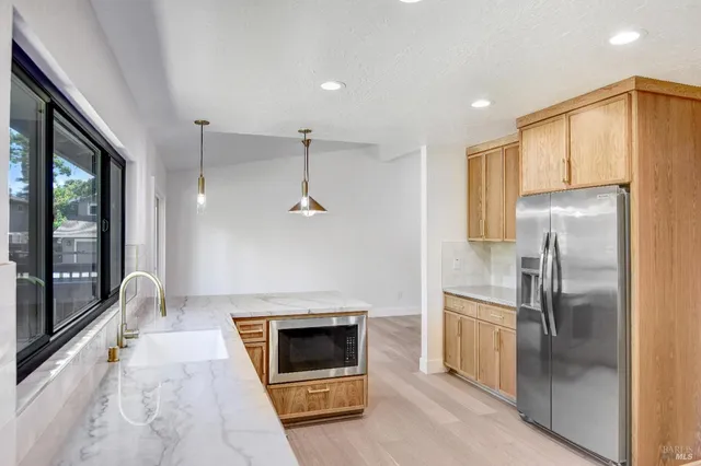 a kitchen with stainless steel appliances granite countertop a stove and a large window