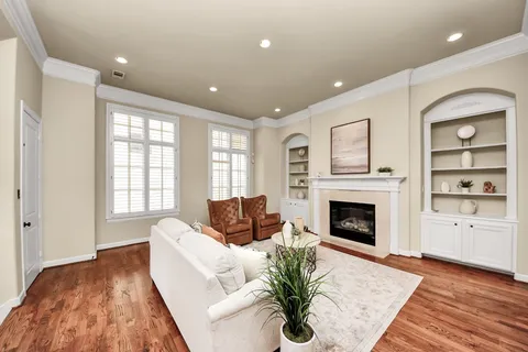 a living room with furniture fireplace and wooden floor