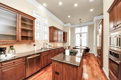 a kitchen with granite countertop a sink stove and cabinets
