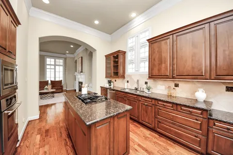 a kitchen with granite countertop a sink stove and cabinets