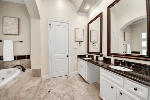 a bathroom with double vanity sinks double vanity tub and a mirror