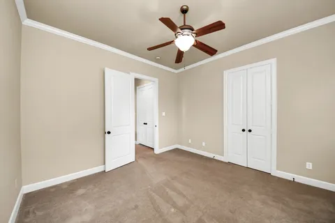 an empty room with closet and a chandelier fan