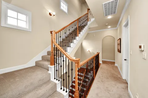 a view of staircase with lots of frames on wall and windows