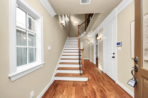 a view of a hallway with wooden floor and staircase