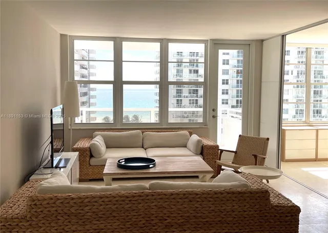 a living room with furniture and a floor to ceiling window