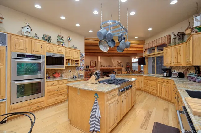 a large kitchen with stainless steel appliances granite countertop a stove and cabinets