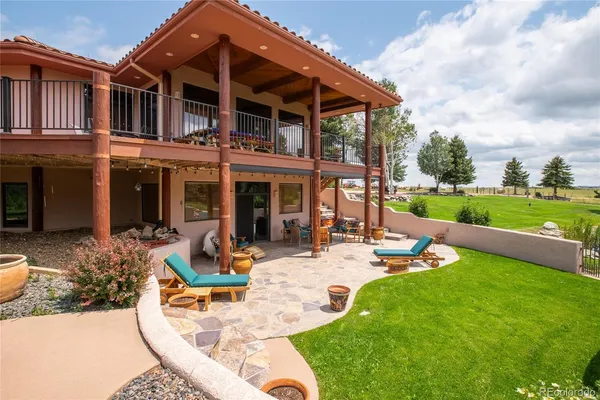 a view of a house with backyard sitting area and garden