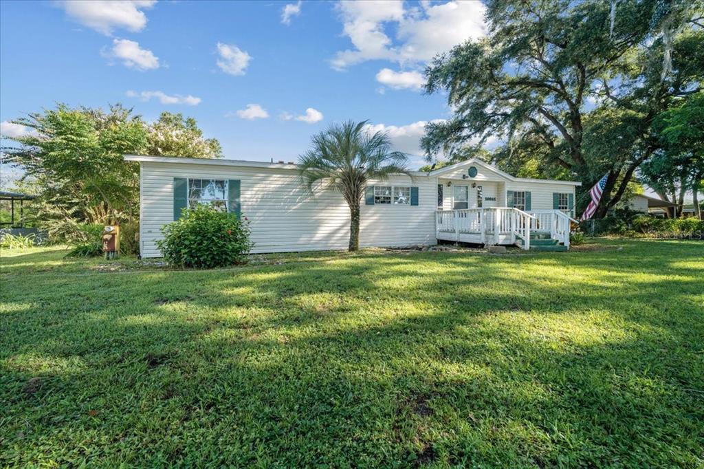 10865 Southeast Timucuan Road Summerfield, FL 34491 - Photo 1 of 35 a house that is sitting in the grass with large trees