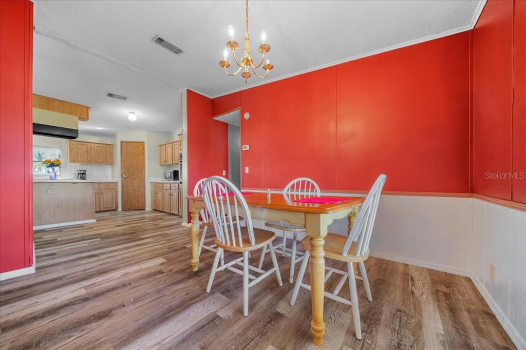 10865 Southeast Timucuan Road Summerfield, FL 34491 - Photo 12 of 35 a dining room with furniture and wooden floor