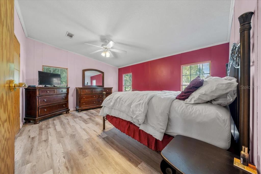 10865 Southeast Timucuan Road Summerfield, FL 34491 - Photo 19 of 35 a bedroom with a bed dresser and a flat screen tv