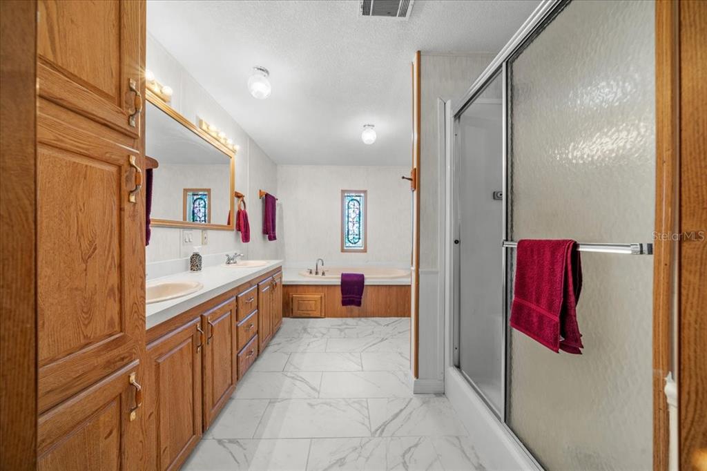 10865 Southeast Timucuan Road Summerfield, FL 34491 - Photo 20 of 35 a bathroom with a tub and shower
