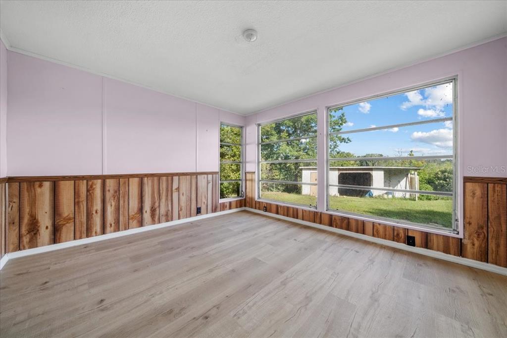 10865 Southeast Timucuan Road Summerfield, FL 34491 - Photo 27 of 35 wooden floor in an empty room with a large window