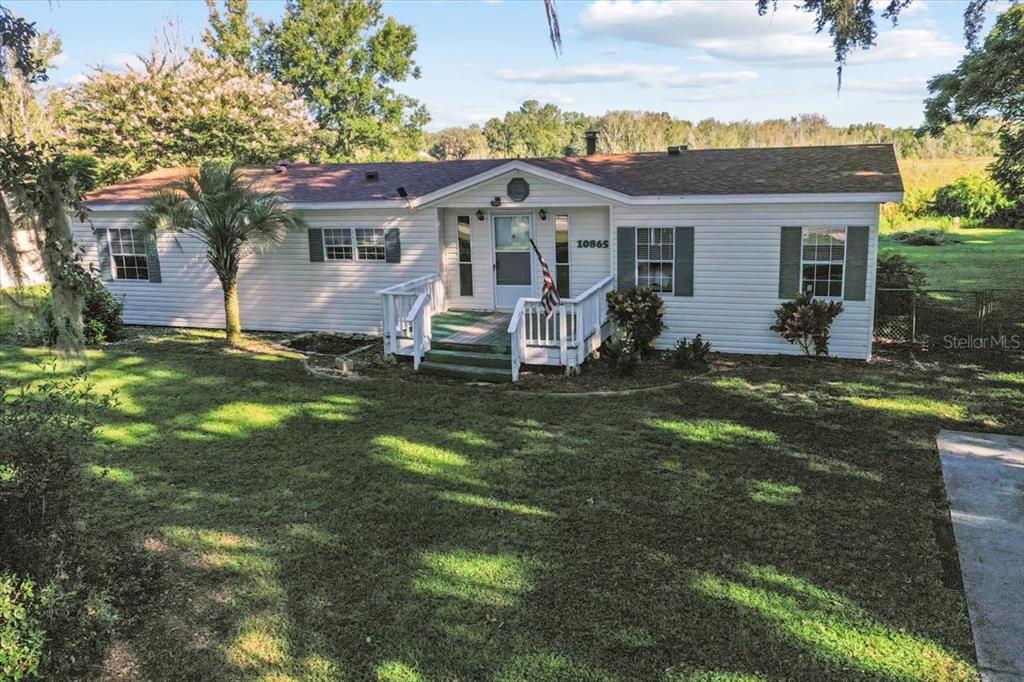 10865 Southeast Timucuan Road Summerfield, FL 34491 - Photo 3 of 35 a front view of a house with a garden and yard