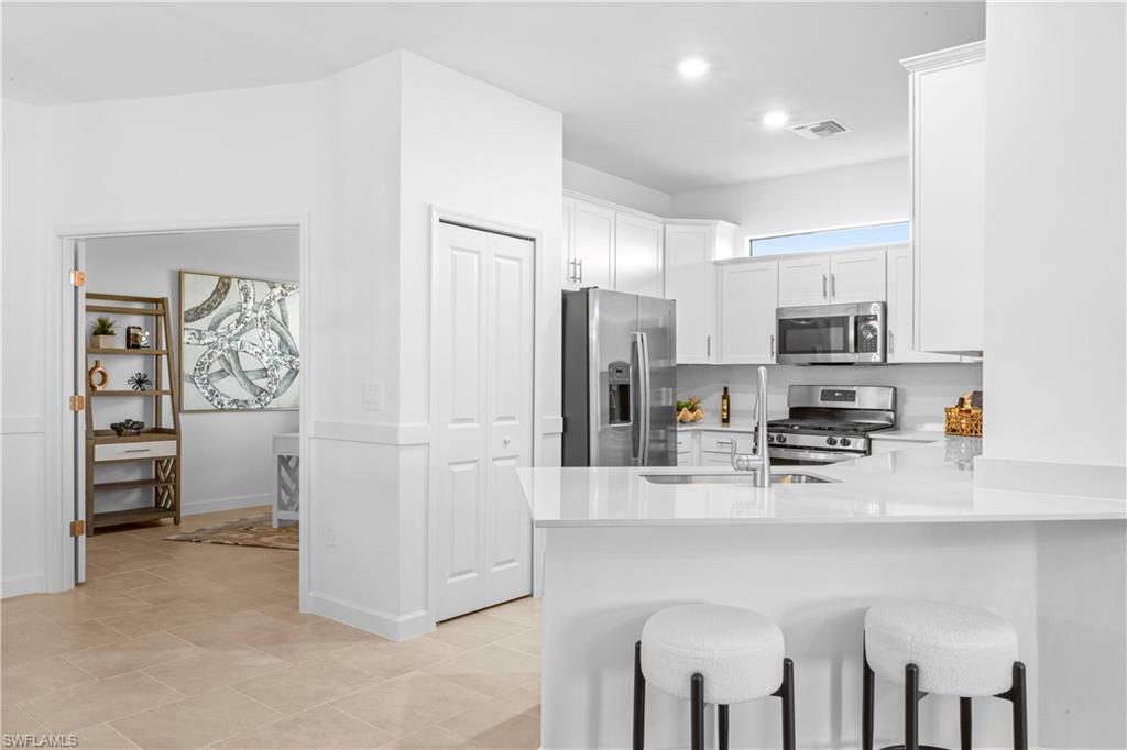 14656 Ballast Way Alva, FL 33920 - Photo 11 of 30 a kitchen with stainless steel appliances a refrigerator stove microwave and sink