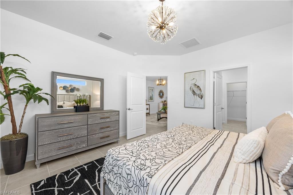 14656 Ballast Way Alva, FL 33920 - Photo 20 of 30 a bedroom with a bed and a chandelier