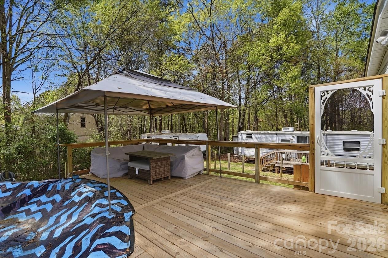 605 Ridgewood Court Mount Holly, NC 28120 - Photo 21 of 32 a view of a patio with table and chairs under an umbrella with large trees