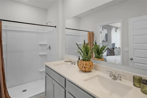 a bathroom with a granite countertop sink a mirror and a shower