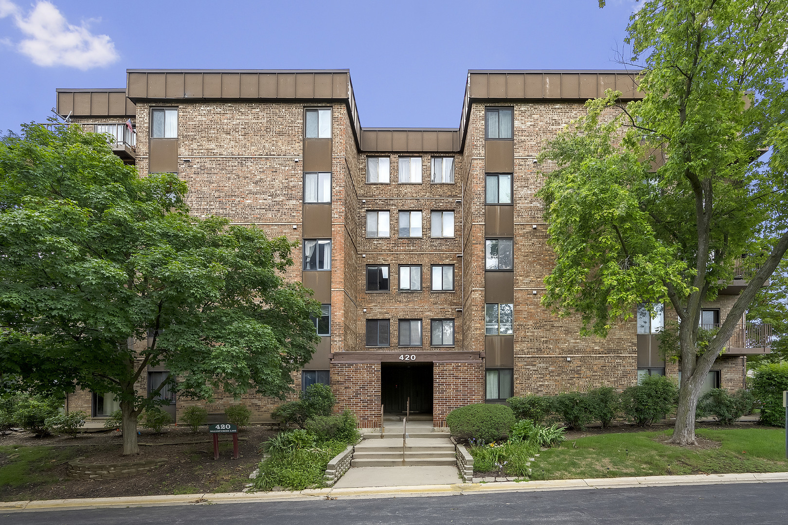 420 Walnut Creek Road, Unit 3406 Lisle, IL 60532 - Photo 1 of 21 a front view of a building with garden