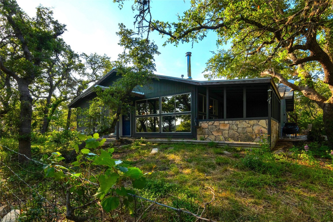 435 Spangenberg Road Blanco, TX 78606 - Photo 4 of 39 a view of a house with floor to ceiling window and a large tree