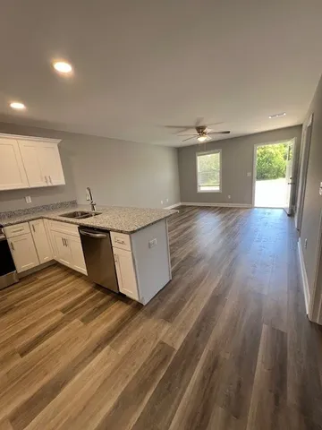 a view of a kitchen with a sink and wooden floor