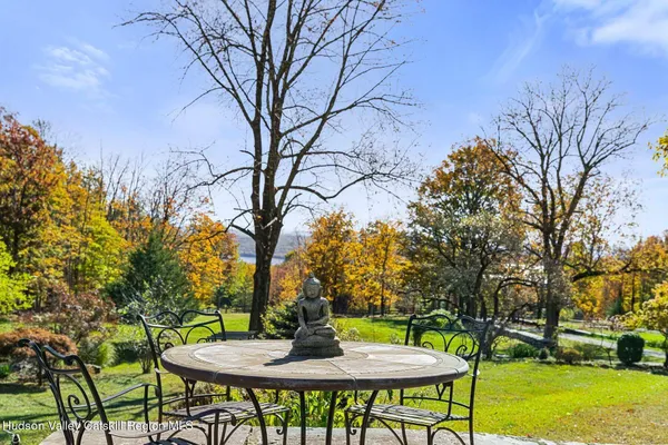 a view of a house with a big yard and large trees