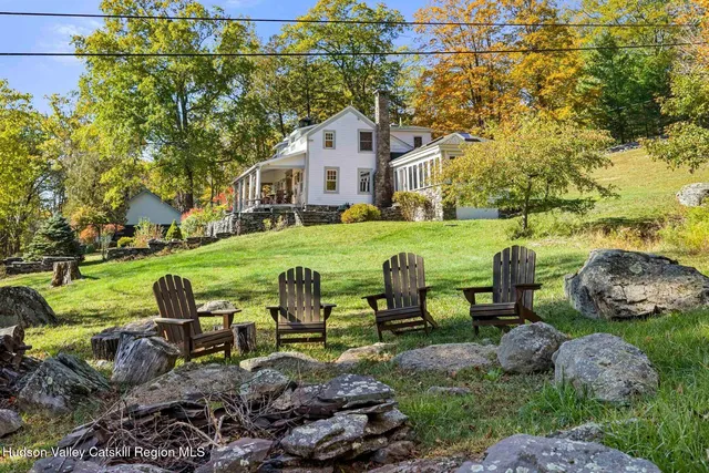 a view of a house with a big yard and large trees