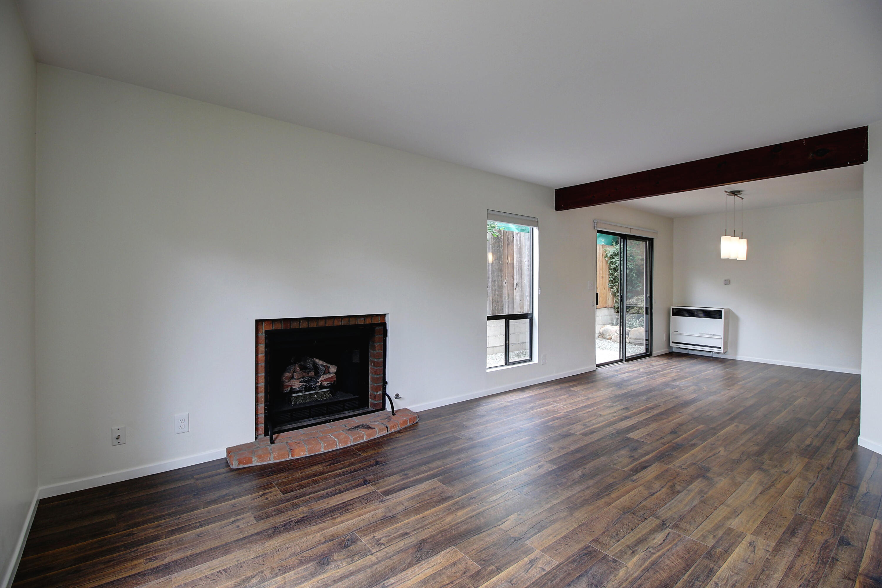1624 Bath Street, Unit B Santa Barbara, CA 93101 - Photo 4 of 16 a view of an empty room with wooden floor fireplace and a window