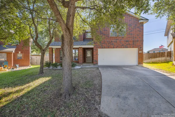 front view of a house with a yard and an trees