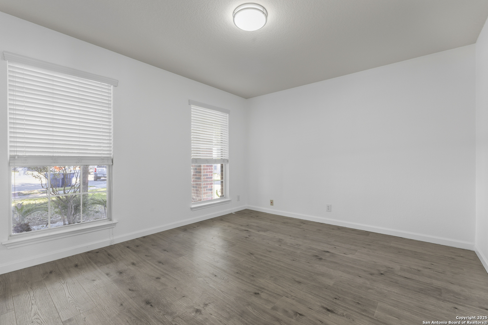 105 Lookout View Cibolo, TX 78108 - Photo 7 of 26 an empty room with wooden floor and windows