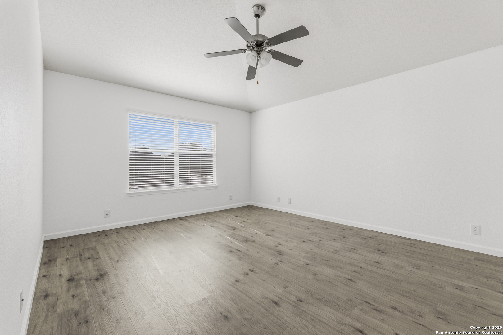 105 Lookout View Cibolo, TX 78108 - Photo 10 of 26 an empty room with wooden floor ceiling fan and windows