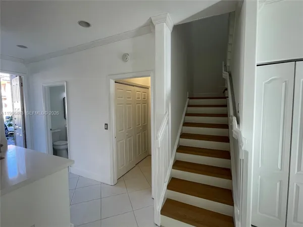 a view of a hallway with entryway and hall with wooden floor