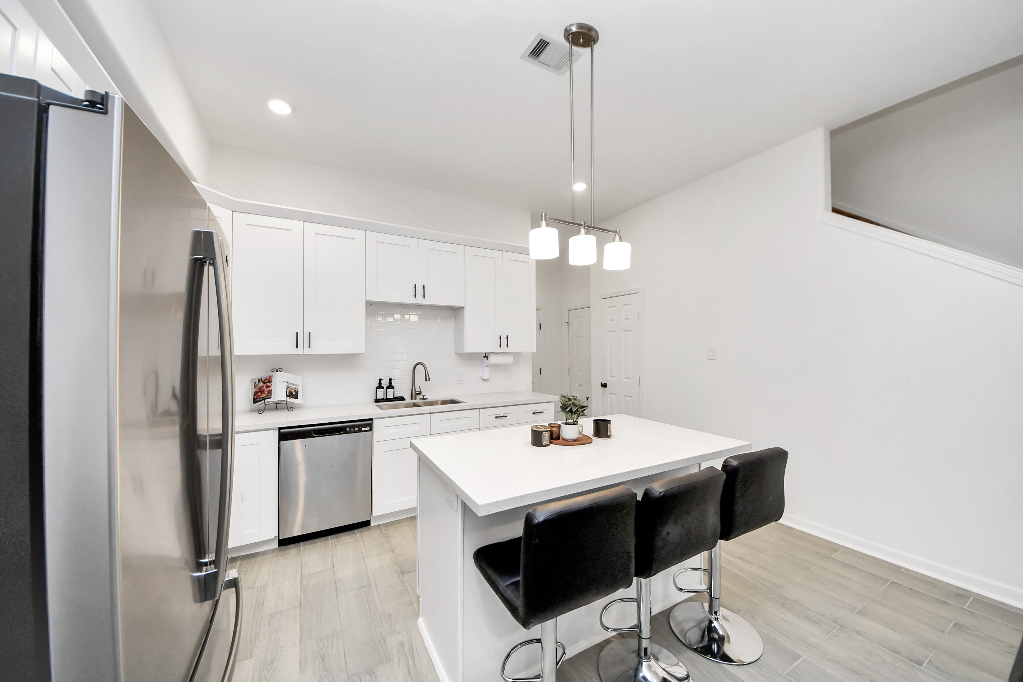 4613 Ireland Street, Unit B Houston, TX 77016 - Photo 13 of 39 a kitchen with stainless steel appliances a stove a sink dishwasher a refrigerator white cabinets and wooden floor