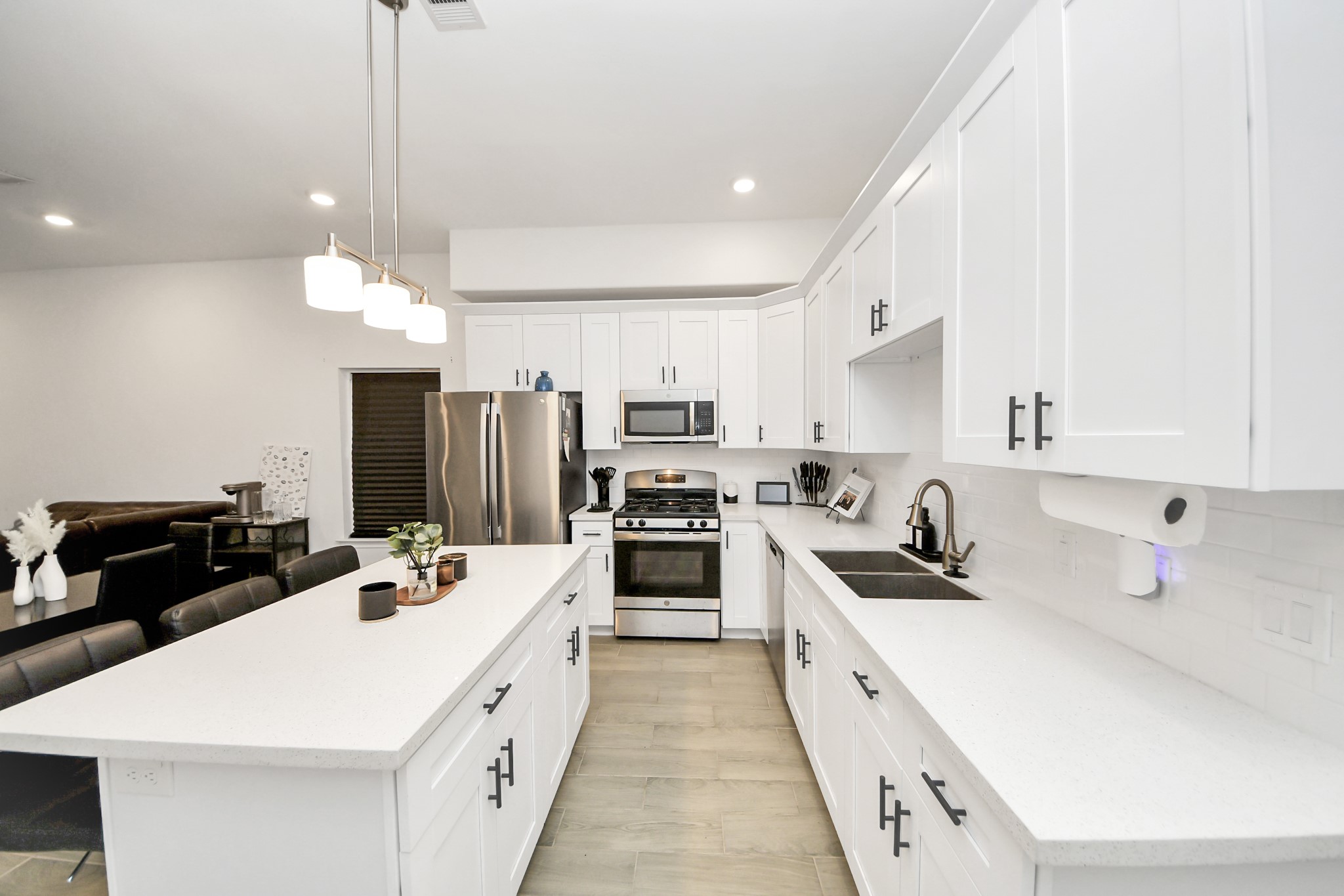 4613 Ireland Street, Unit B Houston, TX 77016 - Photo 5 of 39 a large white kitchen with a stove a sink a refrigerator and cabinets