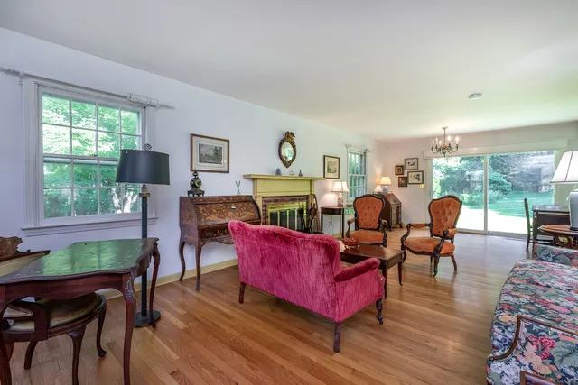 a living room with furniture a large window and wooden floor